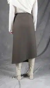 Model wearing an elegant wrap skirt crafted with a wrap skirt pattern, featuring a side button closure and a chic, flowing silhouette, paired with a light blouse and knee-high boots.