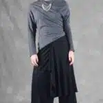 LE SILENCE DU VENT wide-leg pants sewing pattern: front view of black trousers with a draped asymmetric skirt overlay.