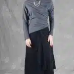 Women’s pants with skirt overlay sewing pattern LE SILENCE DU VENT: full-length front view in black fabric with flowing layered panels.