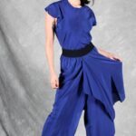 LE SILENCE DU VENT blue wide-leg pants sewing pattern with asymmetrical skirt overlay, shown with the flowing side panel held out.