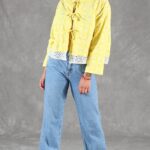 Patrón de costura de chaqueta VALENTINE: chaqueta corta amarilla con lazos delanteros y vaqueros azules anchos.