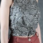MILA sleeveless top sewing pattern, photo of the summer blouse featuring a crossed-back construction and a long waist tie that can wrap around the body.
