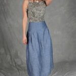 Model wearing a skirt sewn from the Noa gathered skirt sewing pattern, made in blue chambray fabric, featuring a wide yoke waistband and soft gathers, perfect for confident beginners and everyday wear.