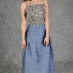 Model wearing a skirt sewn from the Noa gathered skirt sewing pattern, made in blue chambray fabric, featuring a wide yoke waistband and soft gathers, perfect for confident beginners and everyday wear.