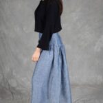 Model wearing a skirt sewn from the Noa gathered skirt sewing pattern, made in blue chambray fabric, featuring a wide yoke waistband and soft gathers, perfect for confident beginners and everyday wear.