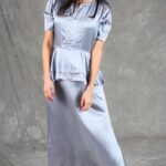 Elegant and flowing silver satin dress with a peplum detail and soft puff sleeves, made from a summer dress sewing pattern