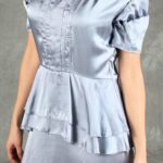 Woman wearing a glamorous silver satin dress with vintage details and peplum waist, perfect for special occasions, created with an event dress sewing pattern
