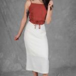 CHARLIZE straight midi skirt sewing pattern: white skirt with front pockets, shown from an angled side view.