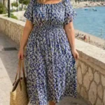 Patrón de costura del vestido DUNE: vestido midi floral azul y blanco de manga corta, combinado con sombrero junto al mar.