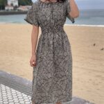 Patrón de costura del vestido DUNE: vestido midi geométrico en blanco y negro con mangas de volante y cintura fruncida, junto a la playa.