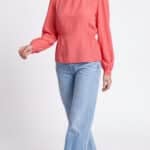 AGATHE blouse sewing pattern: full-length outfit with a coral-pink gathered blouse, voluminous long sleeves and light blue jeans.