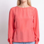 AGATHE blouse sewing pattern: straight-on view of the coral-pink blouse showing its gathered neckline and long sleeves above blue jeans.
