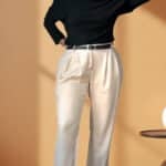 Patron de couture pantalon à plis AUDREY : main dans les cheveux, pantalon crème à revers et bottines noires