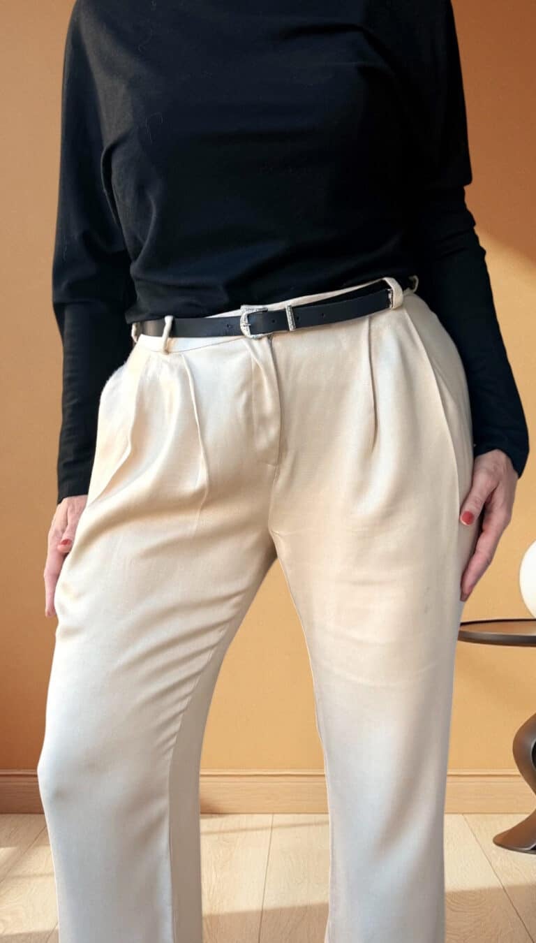 Patron de couture pantalon à plis AUDREY : gros plan sur le devant plissé et la taille ceinturée, mains sur les hanches