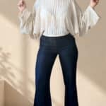 Patrón de costura pantalón acampanado AUDE: pose alegre con los brazos arriba, corte de tiro alto en vaquero oscuro