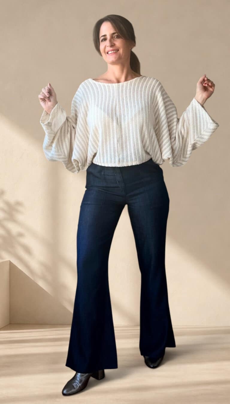 Patrón de costura pantalón acampanado AUDE: pose alegre con los brazos arriba, corte de tiro alto en vaquero oscuro