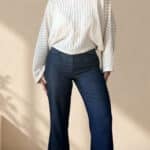 Patrón de costura pantalón acampanado AUDE: vista frontal, vaquero oscuro de tiro alto con jersey blanco amplio
