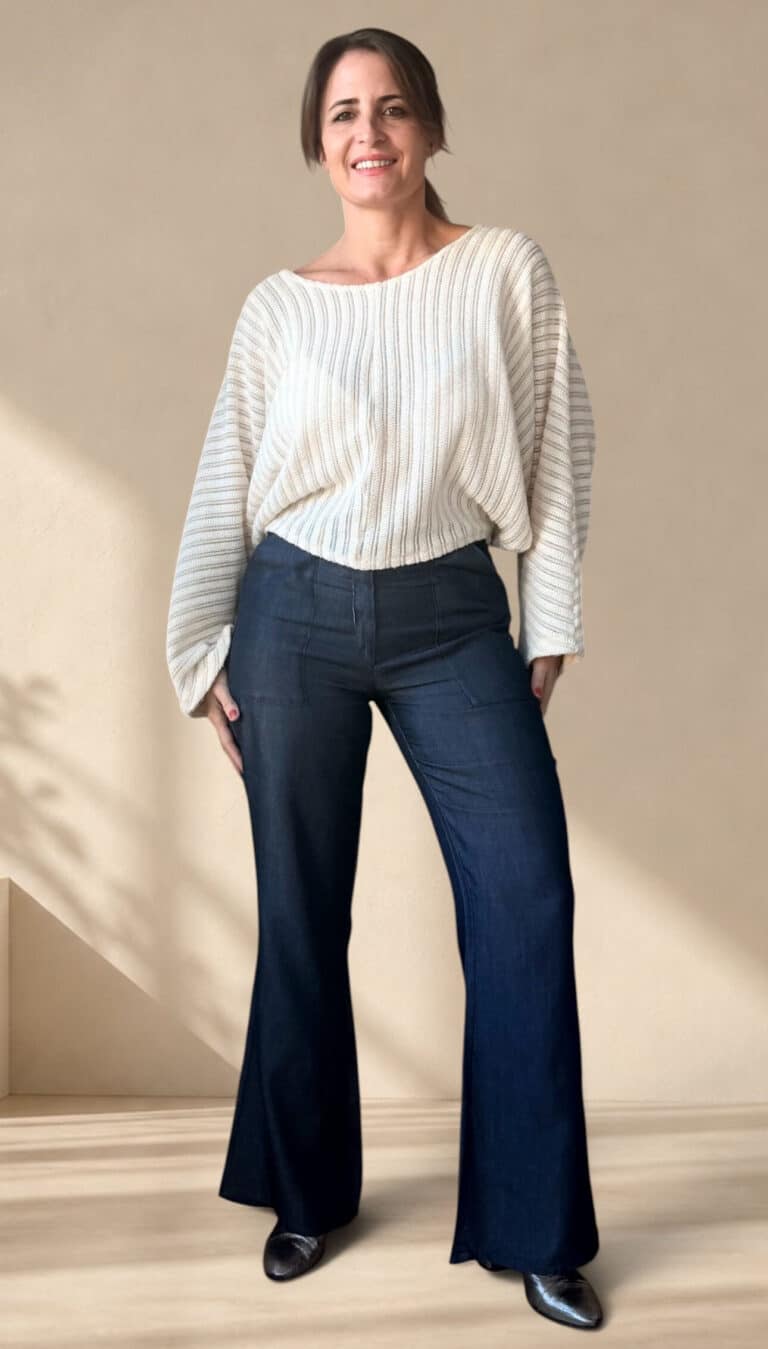 Patron de couture pantalon évasé AUDE : vue de face, denim foncé taille haute porté avec un pull blanc ample