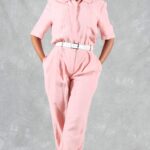 EMMA jumpsuit sewing pattern: woman wearing a pale pink linen jumpsuit with short sleeves and softly pleated trousers.