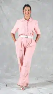 Woman wearing a handmade pink linen jumpsuit with short sleeves and pleated trousers, sewn using a modern utility jumpsuit sewing pattern for intermediate sewists.
