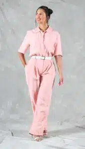 DIY pink linen jumpsuit with front pleats and short sleeves, made from a relaxed-fit one-piece sewing pattern with a shirt collar and side pockets.