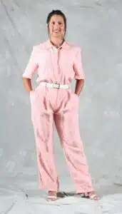 Modern pink jumpsuit with straight-leg silhouette, turned-up hems, and a white belt, sewn from a collared jumpsuit pattern with a clean, minimalist style.