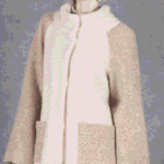 Women’s high-collar jacket sewing pattern JOY: model wearing the cream and beige jacket with patch pockets.
