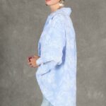 GALATEE relaxed shirt sewing pattern: side view of the pale-blue floral shirt showing its rounded back hem, longer than the front.