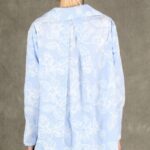 GALATEE long-sleeve shirt sewing pattern: back view of the pale-blue floral shirt with a central box pleat and longer curved hem.