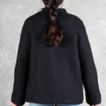 LYNN oversized jacket sewing pattern: back view of the black jacket with gently flared hem, paired with light blue jeans.