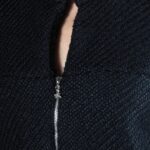 LYNN zip-front jacket sewing pattern: close-up of the rounded neckline, small front opening and zipper in textured black fabric.