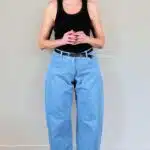 BALLOON barrel-leg pants sewing pattern: front view of high-waisted light blue jeans with rounded legs and a black top.