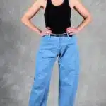 Women’s barrel-leg trousers sewing pattern BALLOON: front view of light blue denim pants with curved, roomy legs.