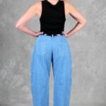 Back view of BALLOON barrel-leg pants sewing pattern: light blue high-waisted jeans with curved, wide legs.