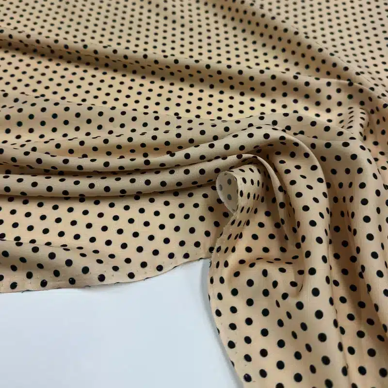 Tejido beige nude cálido con pequeños lunares negros - tejido ligero y fluido de verano de Torretto Tessuti