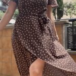 SIENNA wrap dress sewing pattern: close-up outdoors of the brown polka-dot dress with V-neck, waist bow and draped wrap skirt.