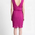 Back view of the NAIA dress sewing pattern, showing the crossed open-back design and elasticated waist in fuchsia fabric.