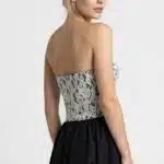 ECLIPSE women’s bustier sewing pattern viewed from the back at an angle, with a shaped floral lace bodice and black skirt.
