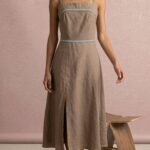 Schnittmuster für das taillierte Midikleid VIENNE in Beige, in Bewegung fotografiert mit weich schwingendem Rock.