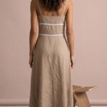 Rückansicht des Kleidschnittmusters VIENNE in Beige mit Spitzenbändern an Rücken und Taille und ausgestelltem Midirock.