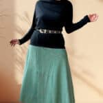 Button-front patchwork skirt sewing pattern CHANTELLE: sage green midi skirt worn with a black long-sleeve top and boots