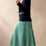Model wearing a skirt made from the CHANTELLE sewing pattern: the cut combines a neat waistband with a distinctly flared skirt. A creative take on a structured skirt design.